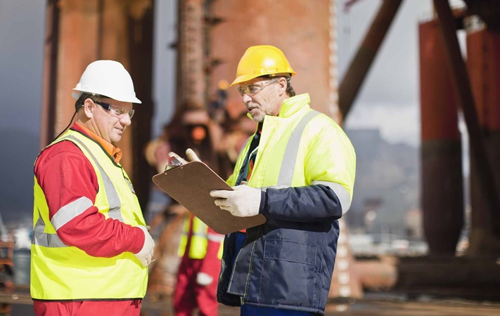 Workers talking on oil rig